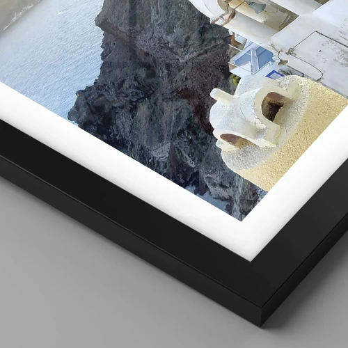 Plakat i sort ramme - Santorini - omfavnet af klipperne - 70x50 cm