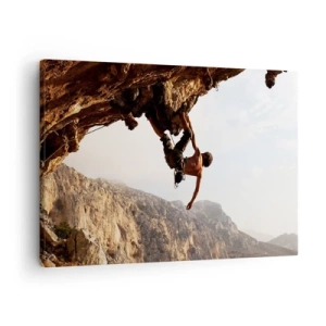 Lærredstryk - Billede på lærred - En klatrer på en stejl klippe i bjergene i solskin - 70x50cm - Verden skrumpede ind i en håndfuld på en klippeskrænt - Moderne vægdekoration til stue og soveværelse ARTTOR