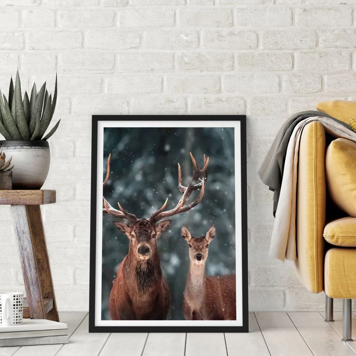 Plakat i sort ramme - Et par hjorte mod en vinterskov som baggrund - 50x70cm - Skovens herre og hans kone - Moderne vægdekoration til stue og soveværelse ARTTOR
