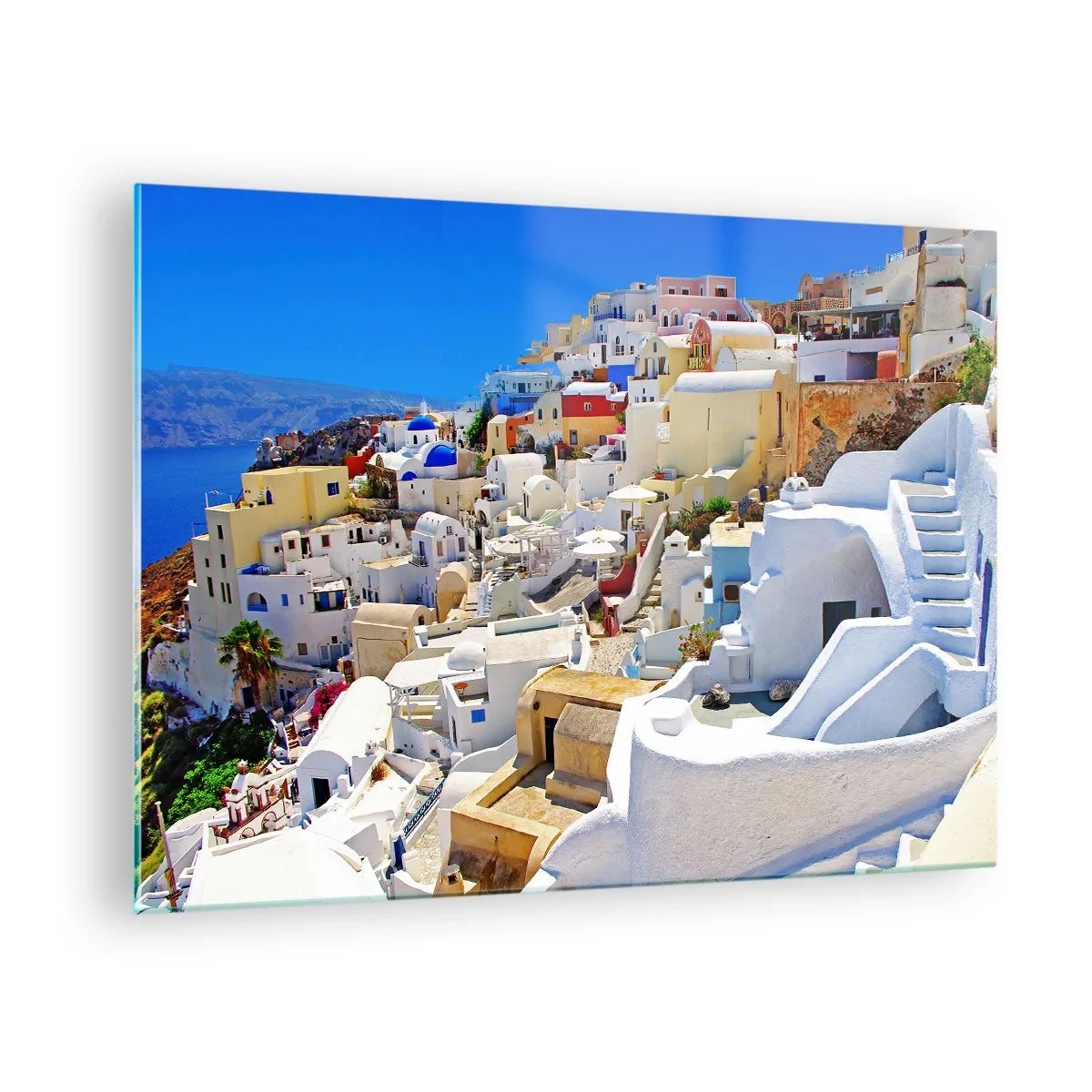Billede på glas - Santorini med hvide huse mod en blå himmel - 70x50cm - Drømme om en græsk sommer - Moderne vægdekoration til stue og soveværelse ARTTOR