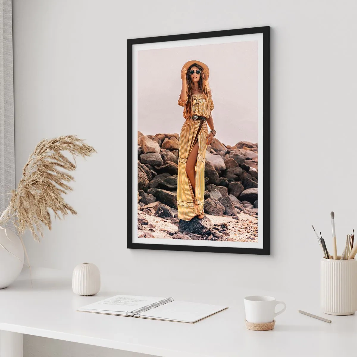 Plakat i sort ramme - Stilfuld kvinde i en boho-kjole mod en klippefyldt baggrund - 50x70cm - Magien ved sten - Moderne vægdekoration til stue og soveværelse ARTTOR