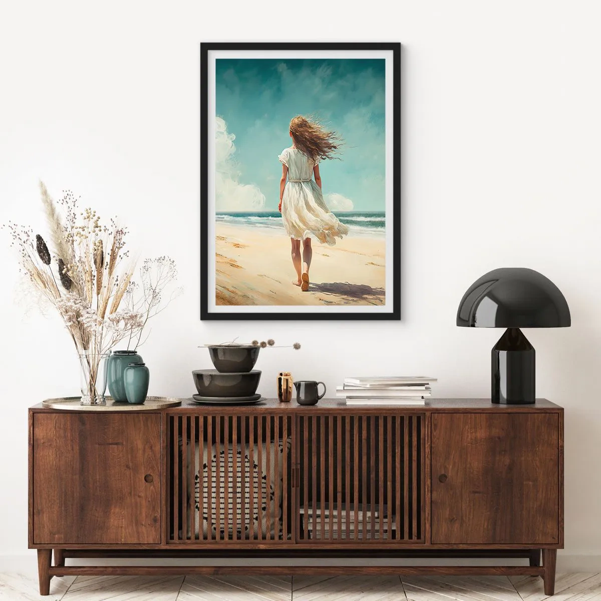 Plakat i sort ramme - En kvinde i en hvid kjole går på stranden ved havet - 50x70cm - At møde solen og vinden - Moderne vægdekoration til stue og soveværelse ARTTOR