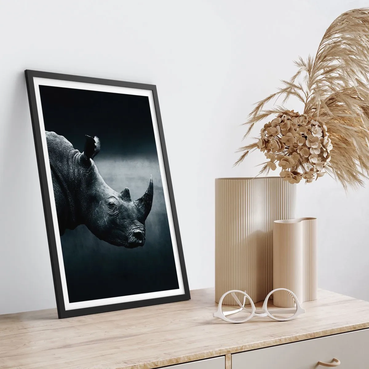 Plakat i sort ramme - Sort-hvidt portræt af et næsehorn mod en mørk baggrund - 50x70cm - Højre profil - Moderne vægdekoration til stue og soveværelse ARTTOR