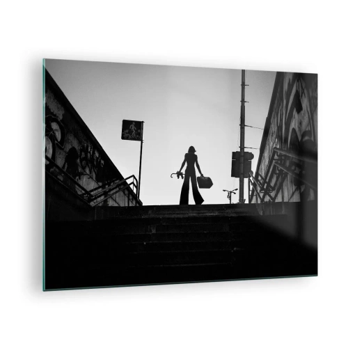 Billede på glas - Sort-hvid silhuet af en kvinde mod en bylandskabs baggrund - 70x50cm - Vandring i byen - Moderne vægdekoration til stue og soveværelse ARTTOR