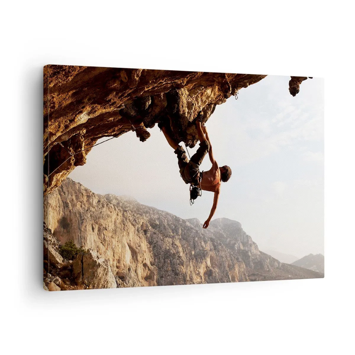 Lærredstryk - Billede på lærred - En klatrer på en stejl klippe i bjergene i solskin - 70x50cm - Verden skrumpede ind i en håndfuld på en klippeskrænt - Moderne vægdekoration til stue og soveværelse ARTTOR