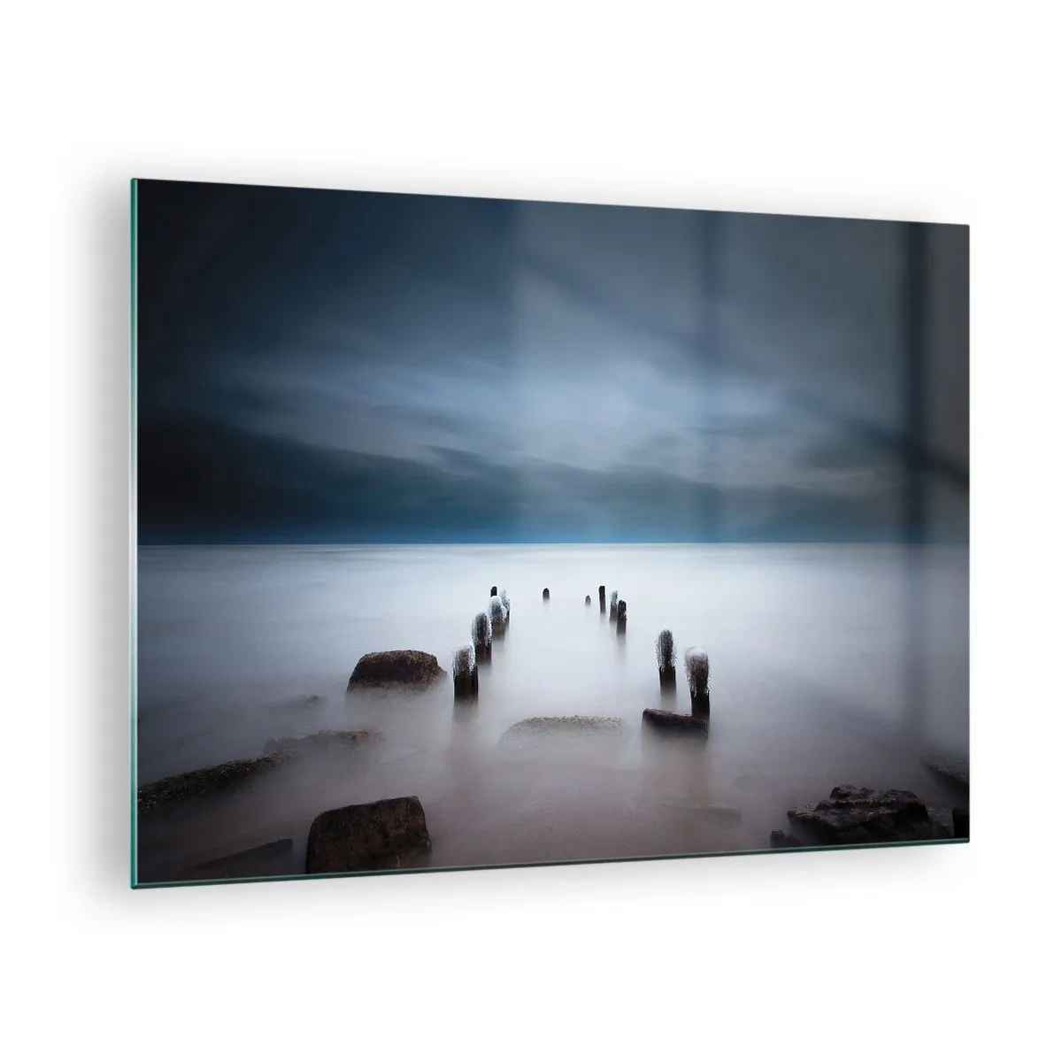 Billede på glas - Atmosfærefyldt kystlandskab med træpæle - 70x50cm - En betænksom sø - Moderne vægdekoration til stue og soveværelse ARTTOR