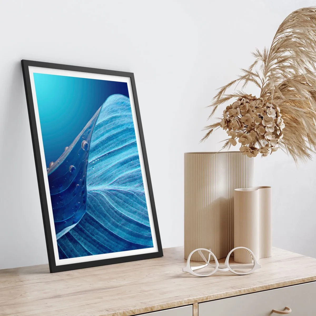Plakat i sort ramme - Et blad med vanddråber i blå nuancer - 50x70cm - Skjulte dråber af blåt - Moderne vægdekoration til stue og soveværelse ARTTOR