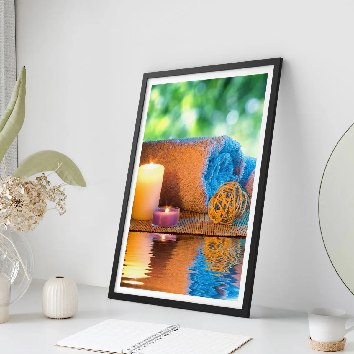 Plakat i sort ramme - Stearinlys og et håndklæde mod et naturligt landskab - 50x70cm - Tid til kroppen - Moderne vægdekoration til stue og soveværelse ARTTOR