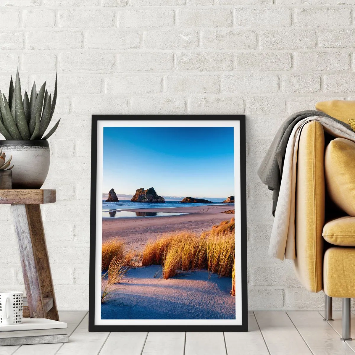 Plakat i sort ramme - En malerisk strand med græs og klipper mod en rolig havbaggrund - 50x70cm - For dem, der søger ro - Moderne vægdekoration til stue og soveværelse ARTTOR