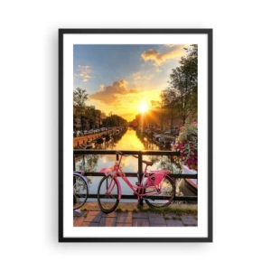 Plakat i sort ramme - En lyserød cykel på en bro over en kanal ved solnedgang - 50x70cm - Forårsmorgen i Amsterdam - Moderne vægdekoration til stue og soveværelse ARTTOR