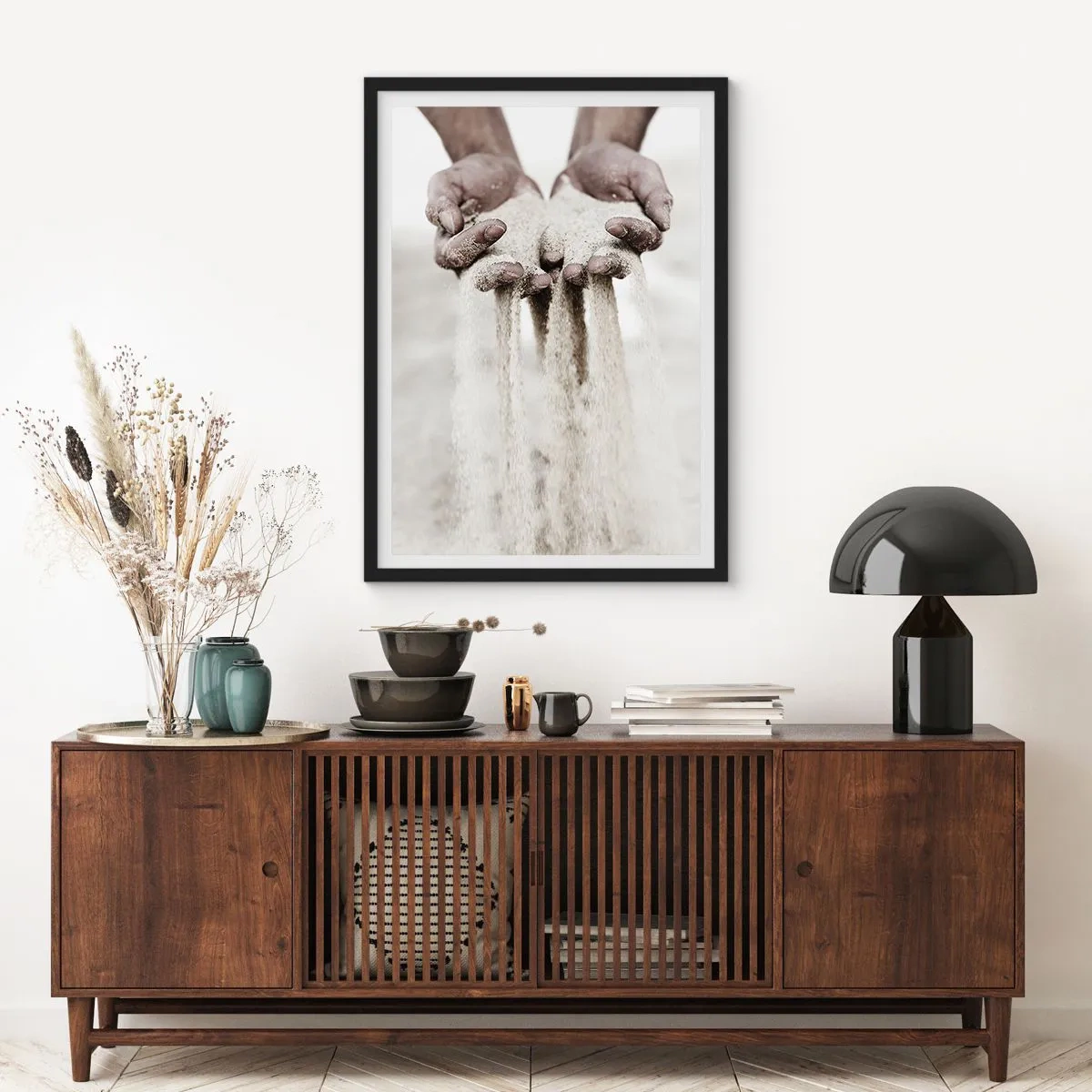 Plakat i sort ramme - Hænder, der holder sand, symboliserer øjeblikkets flygtighed og skrøbelighed - 50x70cm - Med disse hænder... - Moderne vægdekoration til stue og soveværelse ARTTOR
