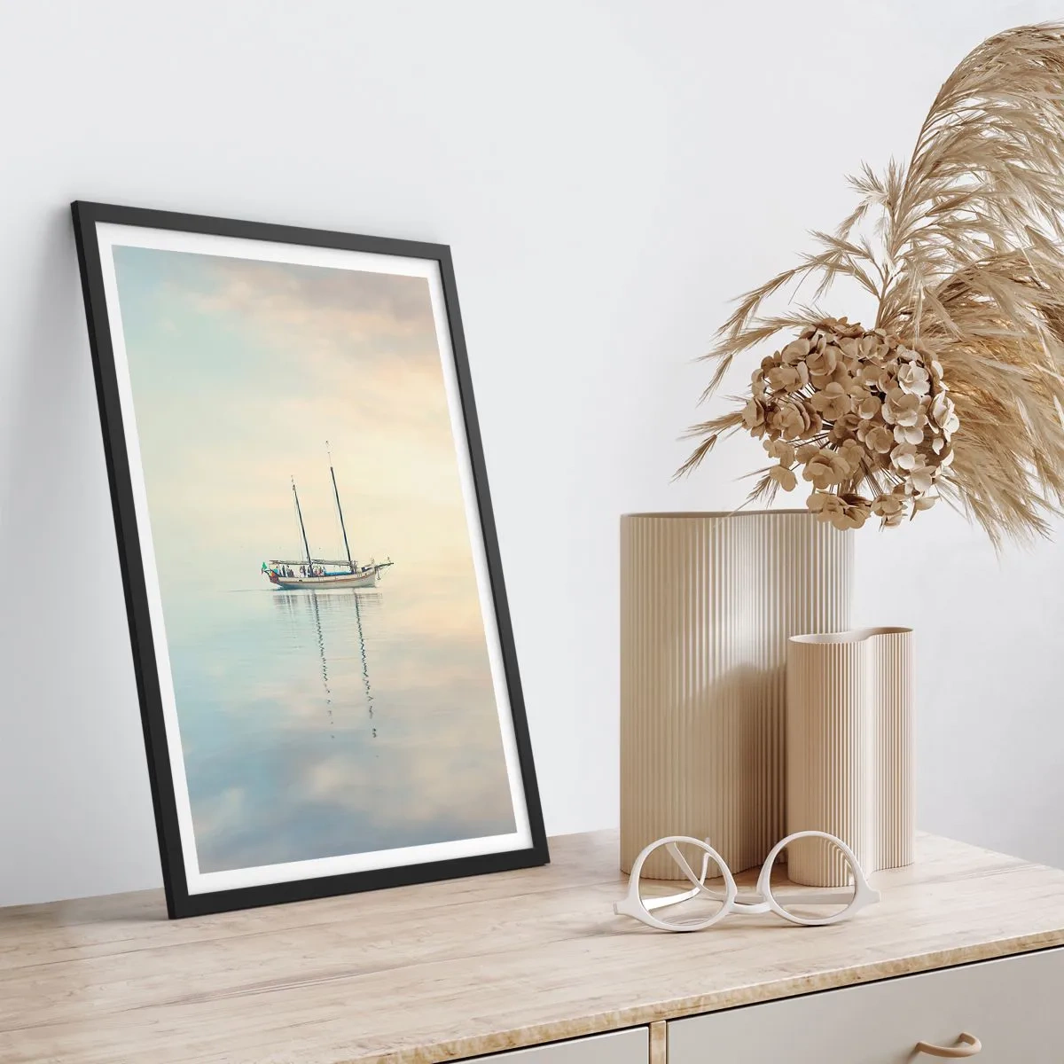 Plakat i sort ramme - Et skib på et roligt hav med en blid refleksion - 50x70cm - I et hav af stilhed - Moderne vægdekoration til stue og soveværelse ARTTOR