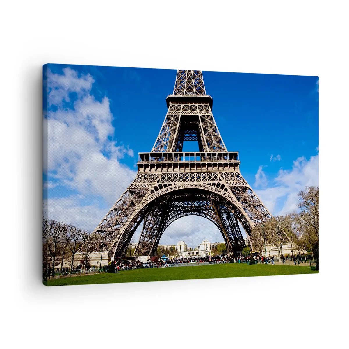 Lærredstryk - Billede på lærred - Eiffeltårnet mod baggrunden af en blå himmel og en grøn park - 70x50cm - Hele Paris ved hendes fødder - Moderne vægdekoration til stue og soveværelse ARTTOR