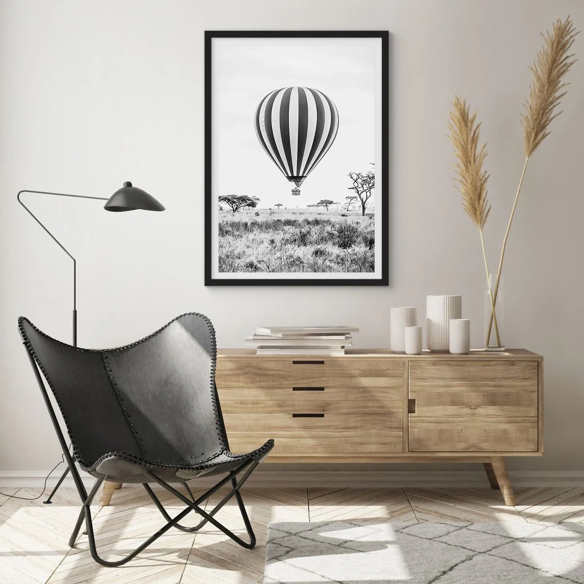 Plakat i sort ramme - En varmluftballon, der svæver over savannen i sort-hvid. - 50x70cm - Over savannen - Moderne vægdekoration til stue og soveværelse ARTTOR