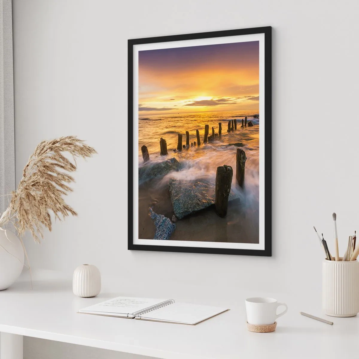 Plakat i sort ramme - Solnedgang over havet med træpæle på stranden - 50x70cm - Østersøens rå skønhed - Moderne vægdekoration til stue og soveværelse ARTTOR