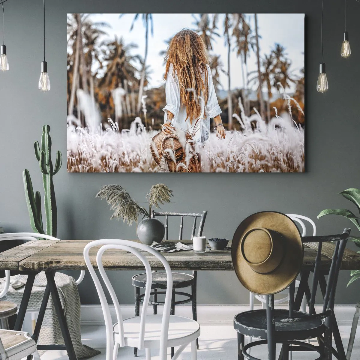 Lærredstryk - Billede på lærred - En kvinde i en græsmark med palmer i baggrunden ved solnedgang - 70x50cm - Født af græsdun - Moderne vægdekoration til stue og soveværelse ARTTOR