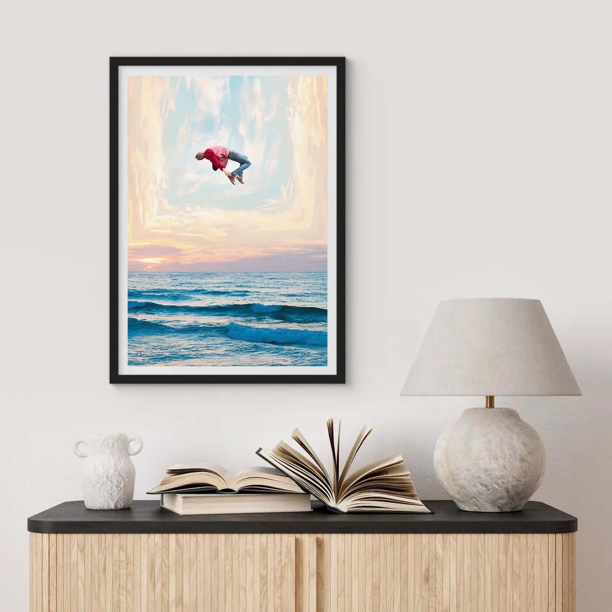 Plakat i sort ramme - En mand hopper op i himlen over havet ved solnedgang - 50x70cm - Til en anden dimension - Moderne vægdekoration til stue og soveværelse ARTTOR