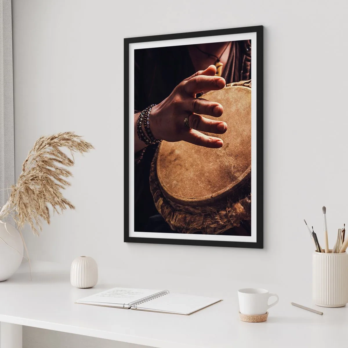 Plakat i sort ramme - En hånd, der spiller på en tromme i varmt lys - 50x70cm - I hjertets rytme - Moderne vægdekoration til stue og soveværelse ARTTOR