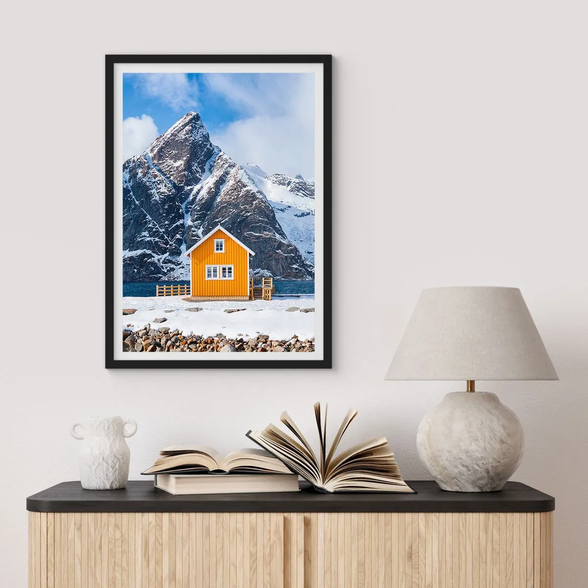 Plakat i sort ramme - Et gult hus mod en baggrund af snedækkede bjerge - 50x70cm - Skandinavisk ferie - Moderne vægdekoration til stue og soveværelse ARTTOR