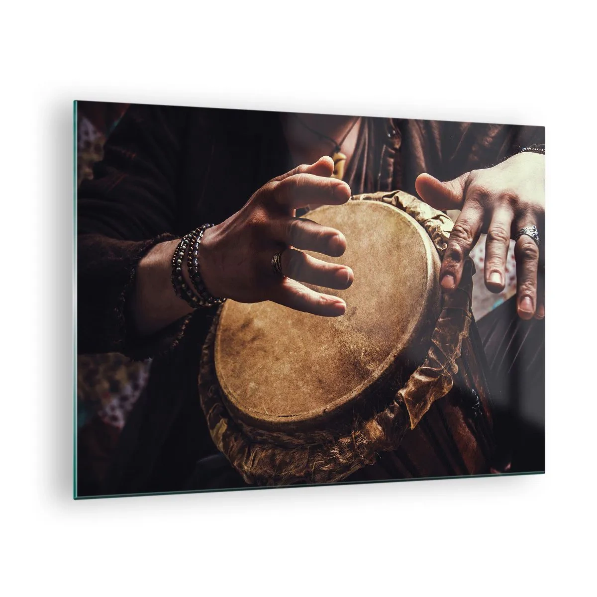 Billede på glas - Nærbillede af hænder, der spiller på en djembe-tromme i varmt lys. - 70x50cm - I hjertets rytme - Moderne vægdekoration til stue og soveværelse ARTTOR