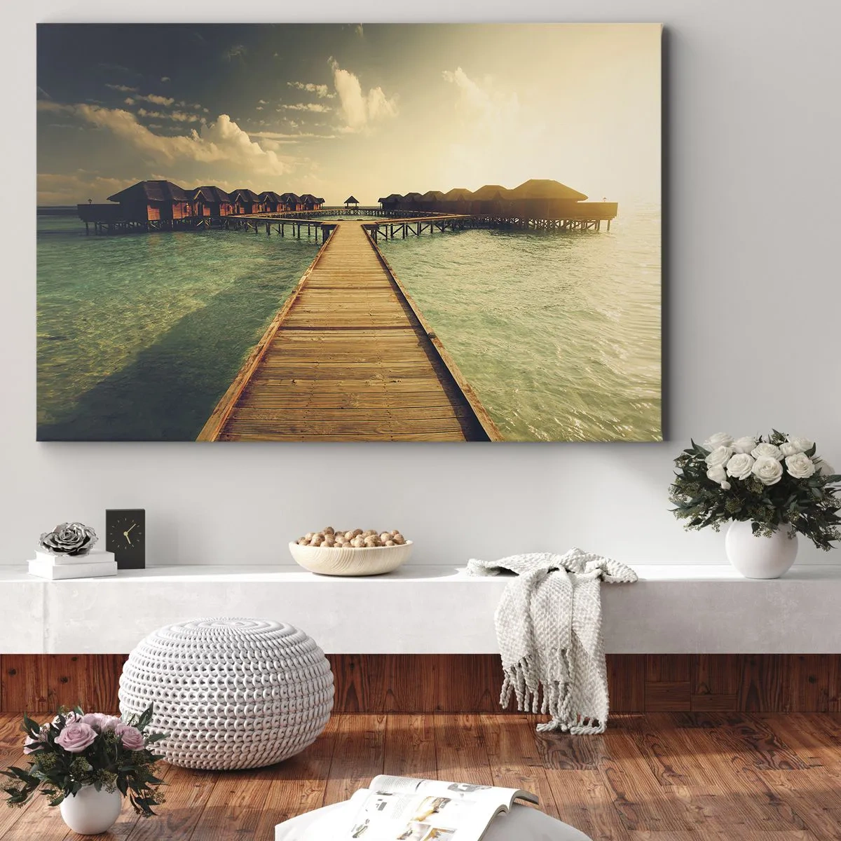 Lærredstryk - Billede på lærred - En træbro, der fører til husene ved vandet, oplyst af solens stråler. - 70x50cm - En varm invitation - Moderne vægdekoration til stue og soveværelse ARTTOR