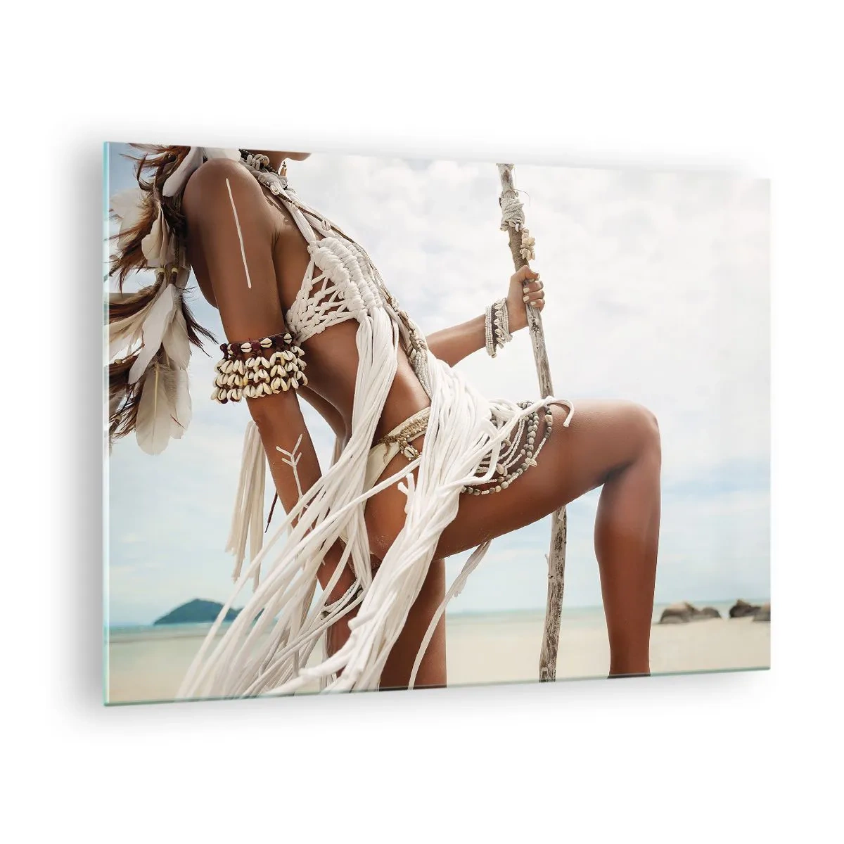 Billede på glas - En kvinde i etnisk tøj med muslingeskaller og en pind på stranden. - 70x50cm - Præstinde af solen - Moderne vægdekoration til stue og soveværelse ARTTOR