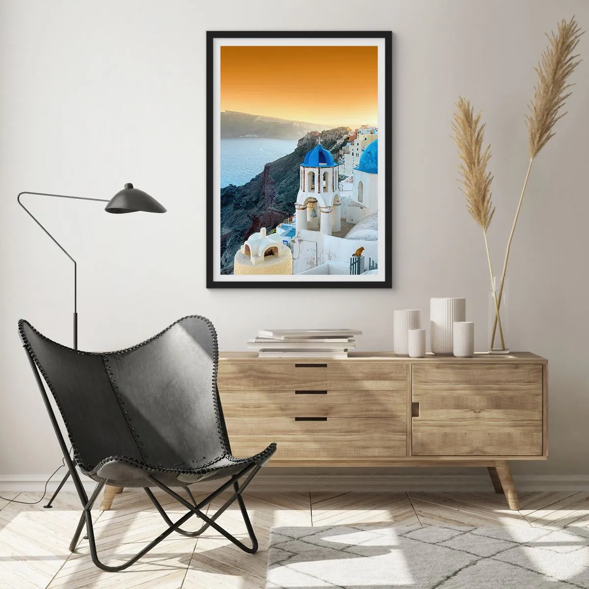 Plakat i sort ramme - Santorini med sine hvide huse og blå kupler - 50x70cm - Santorini - omfavnet af klipperne - Moderne vægdekoration til stue og soveværelse ARTTOR