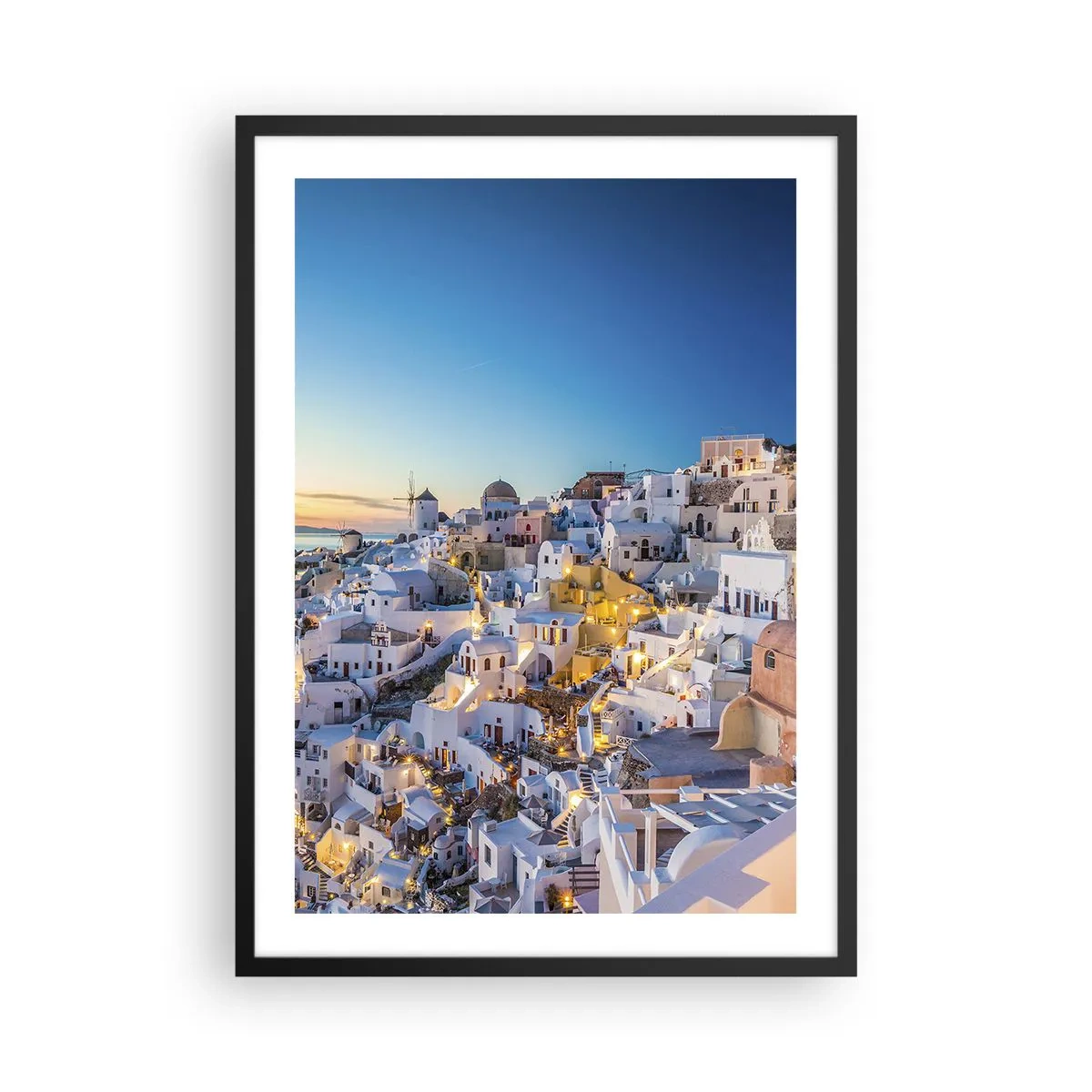 Plakat i sort ramme - Udsigt over de oplyste huse på Santorini ved solnedgang - 50x70cm - Essensen af græskhed - Moderne vægdekoration til stue og soveværelse ARTTOR
