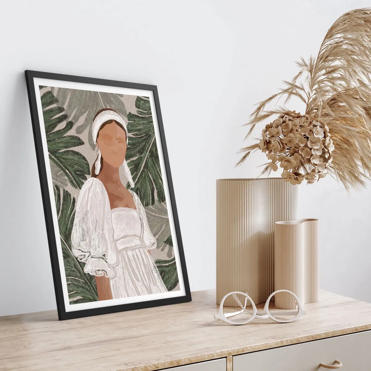 Plakat i sort ramme - En kvinde i en hvid kjole mod en baggrund af grønne blade - 50x70cm - Eksotisk portræt - Moderne vægdekoration til stue og soveværelse ARTTOR