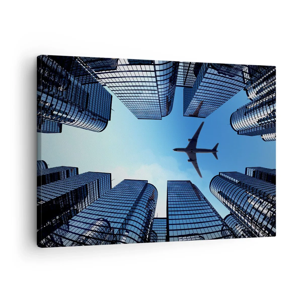 Lærredstryk - Billede på lærred - Et fly, der flyver over moderne skyskrabere i byens centrum. - 70x50cm - Udsigt fra glasslugten - Moderne vægdekoration til stue og soveværelse ARTTOR