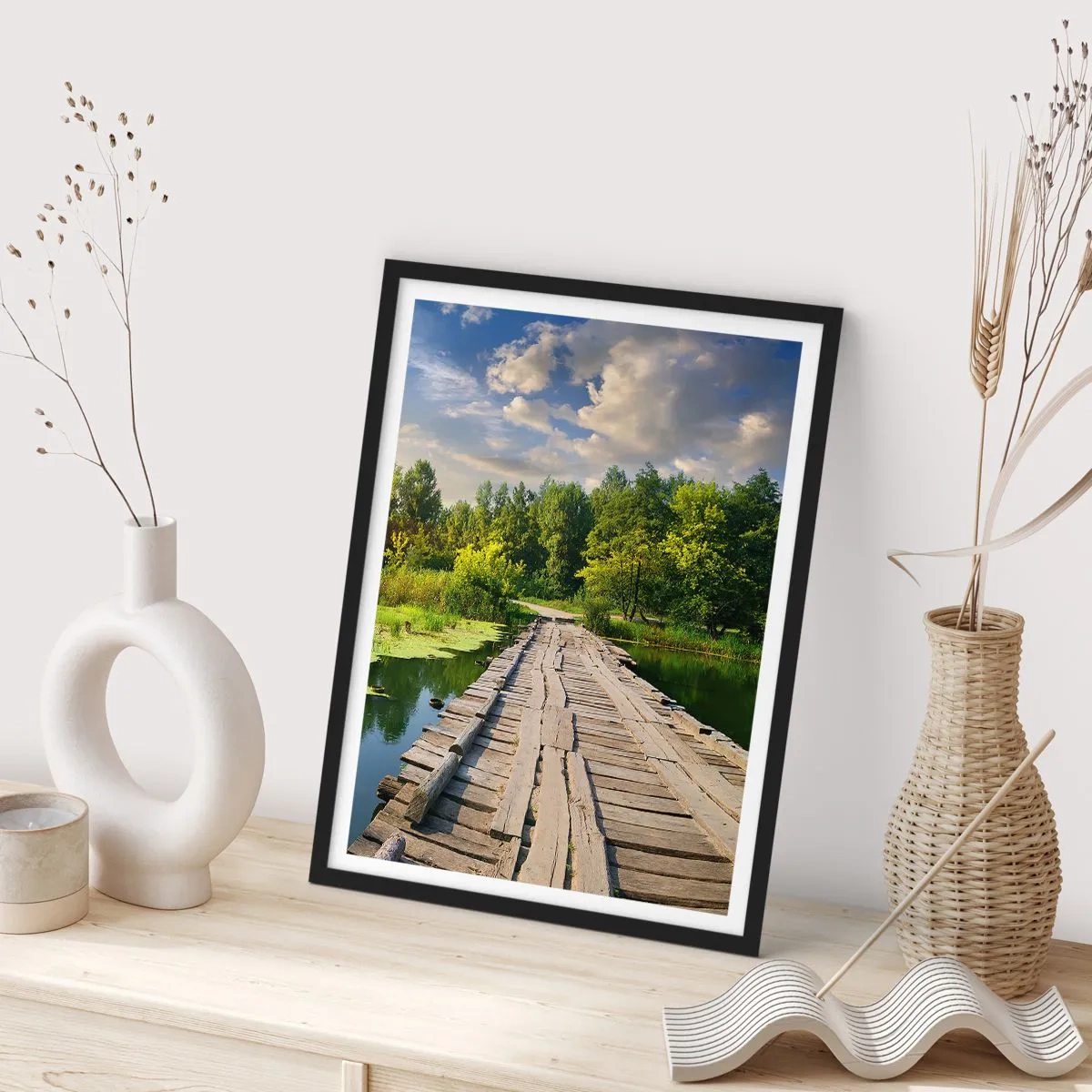 Plakat i sort ramme - En træbro over en flod omgivet af grønne områder - 50x70cm - Sommer, sommer overalt - Moderne vægdekoration til stue og soveværelse ARTTOR