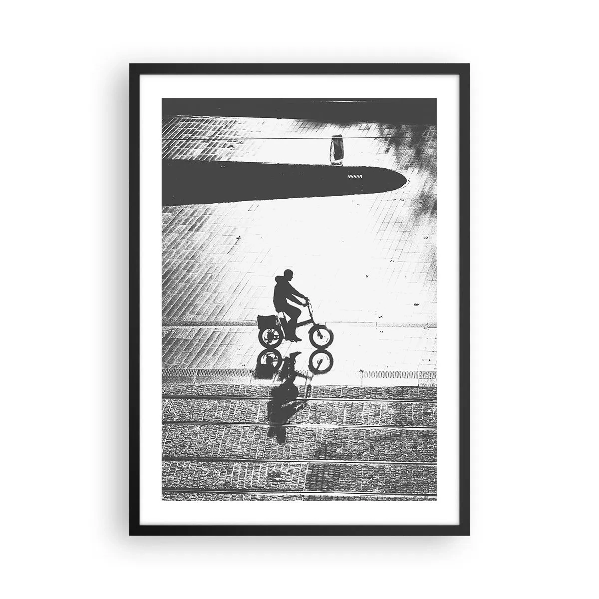 Plakat i sort ramme - Silhuet af en cyklist med en refleksion i en vandpyt i sort-hvid stil - 50x70cm - Fremad, gennem byen - Moderne vægdekoration til stue og soveværelse ARTTOR