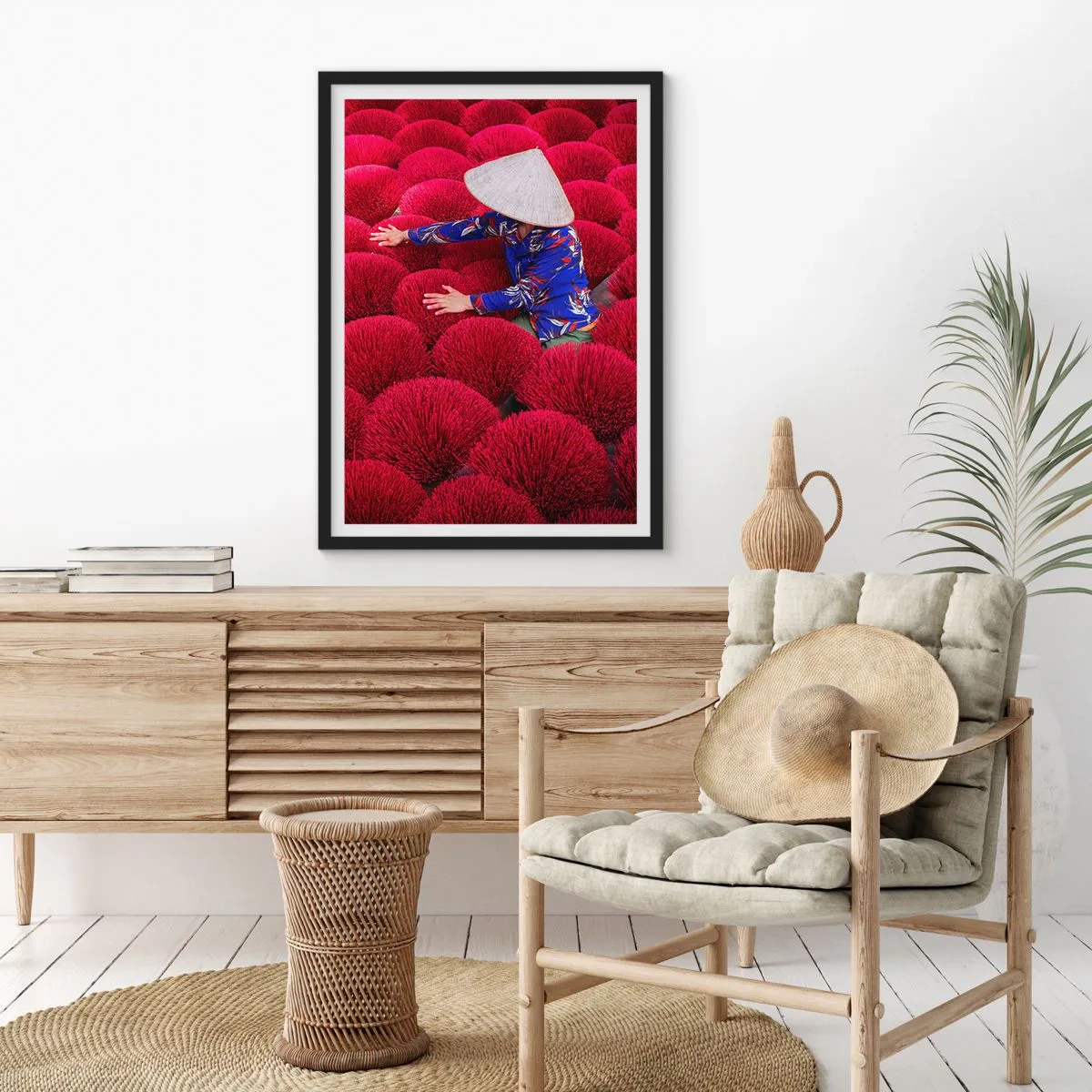 Plakat i sort ramme - En figur i en hat mod en baggrund af røde røgelsespinde - 50x70cm - I en rismark - Moderne vægdekoration til stue og soveværelse ARTTOR