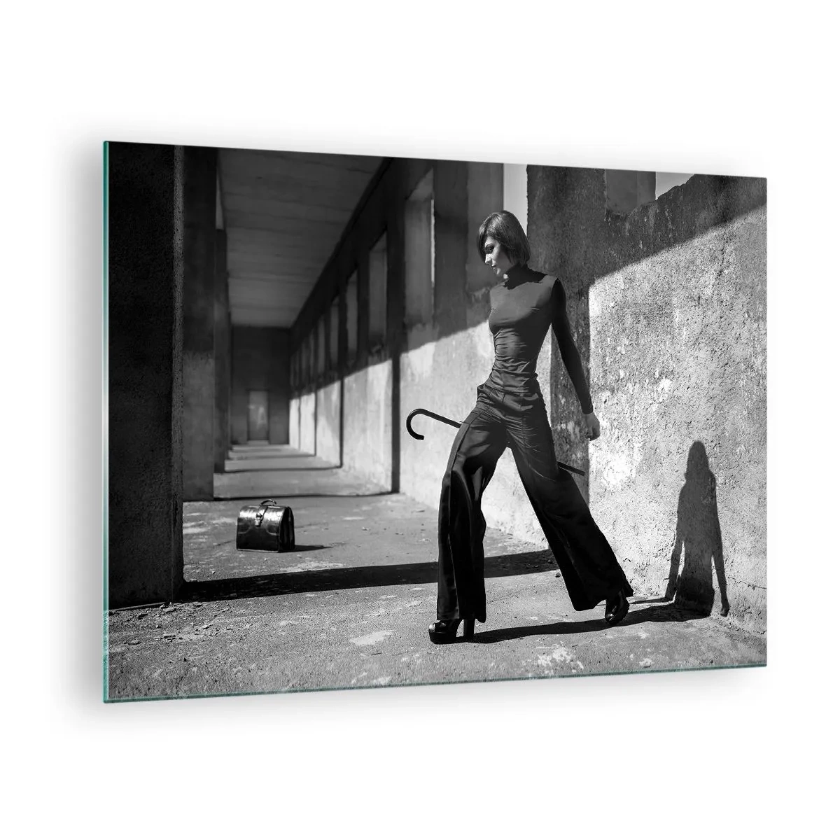 Billede på glas - Sort-hvidt fotografi af en kvinde i et elegant outfit i bymæssige omgivelser. - 70x50cm - Byens elegance - Moderne vægdekoration til stue og soveværelse ARTTOR